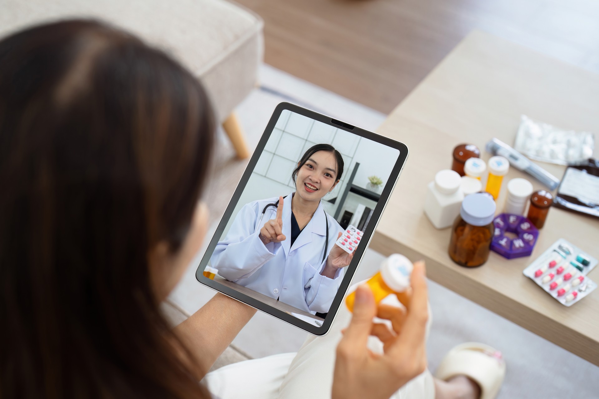 Senior Asian woman video calling with doctor on tablet, consultation health issues and medication online. Doctor concept of telemedicine