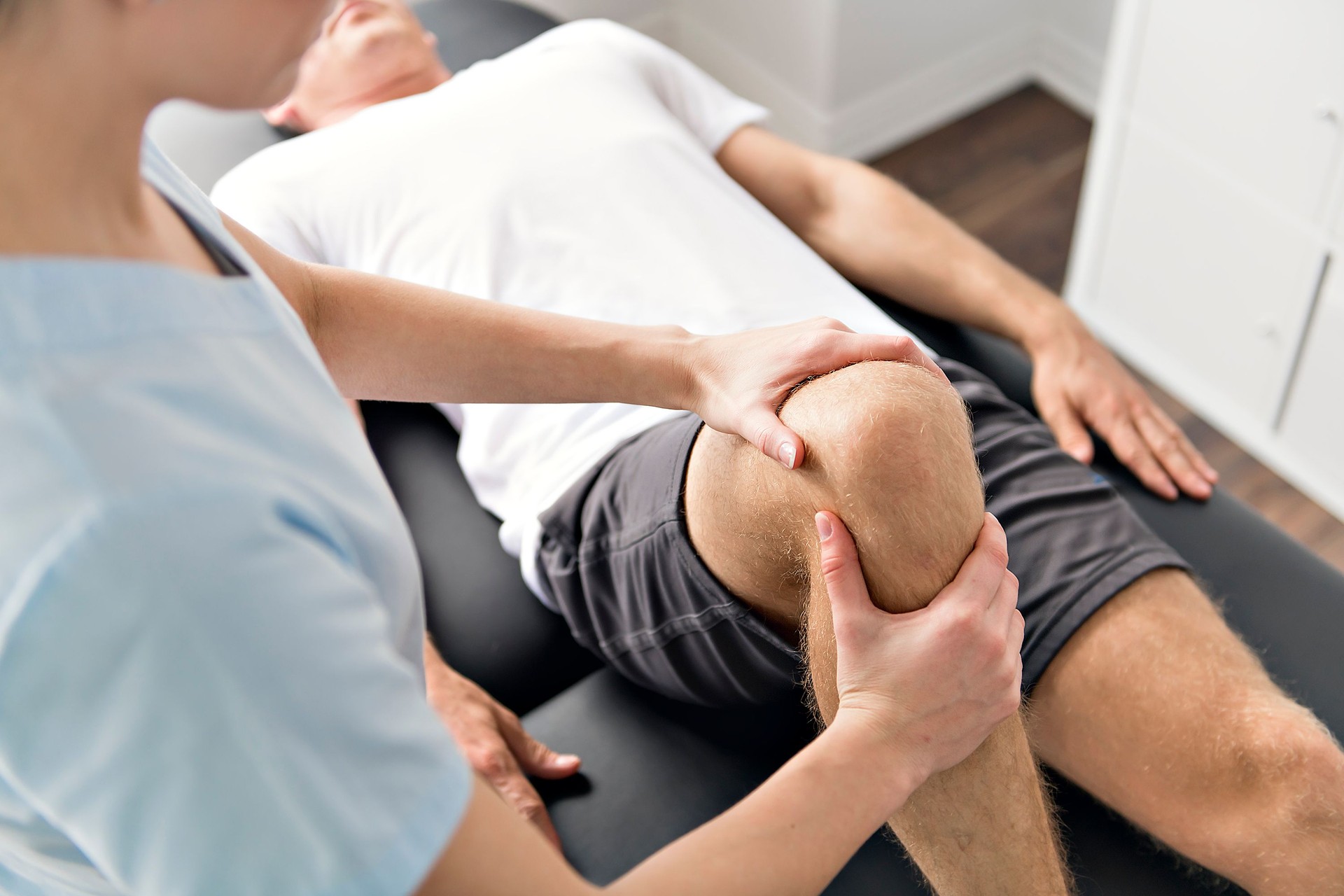 Patient at the physiotherapy doing physical exercises with his therapist