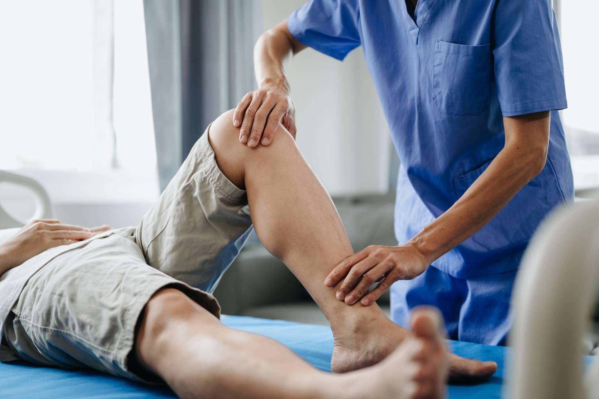 Close up of Physiotherapist working with patient on the bed